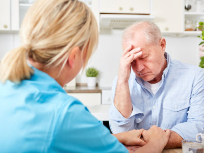 nurse comforts senior man with dementia and depression