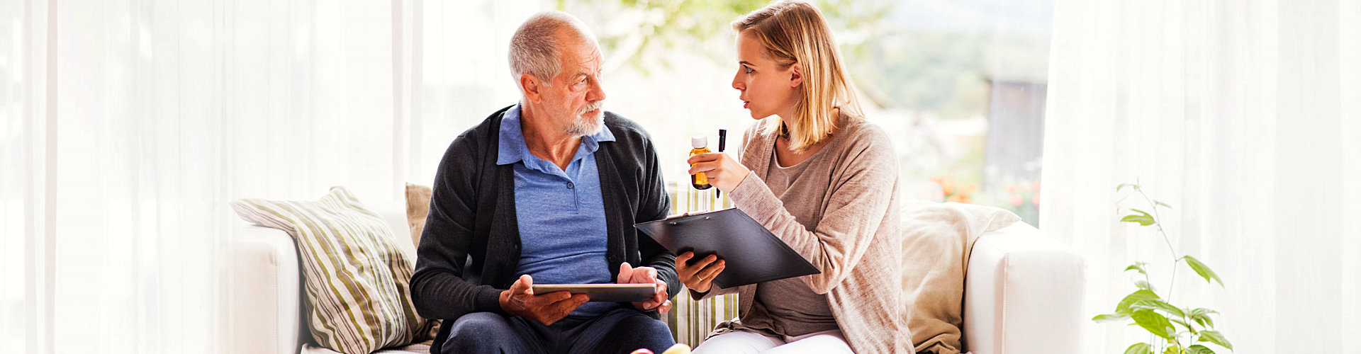 caregiver reminding elderly man about his medications